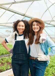 Portrait of two young women working on a farm